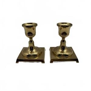 A pair of solid brass candle holders with square bases